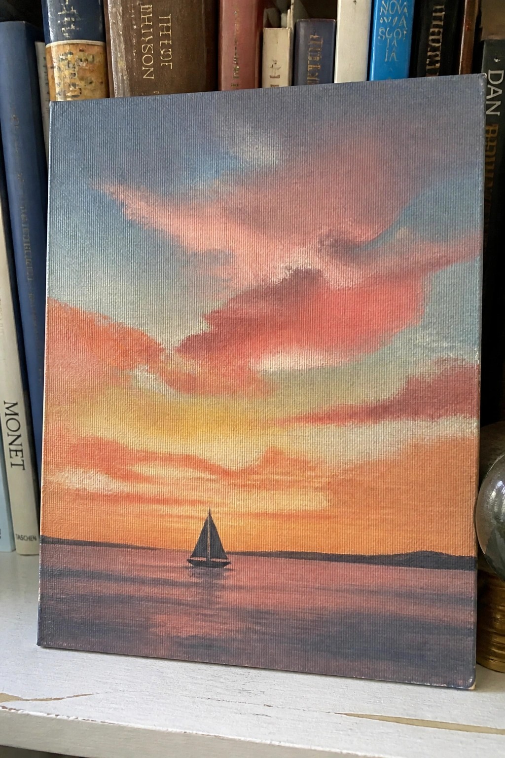 Canvas painting of sailboat on calm water under vibrant pink-orange sunset sky