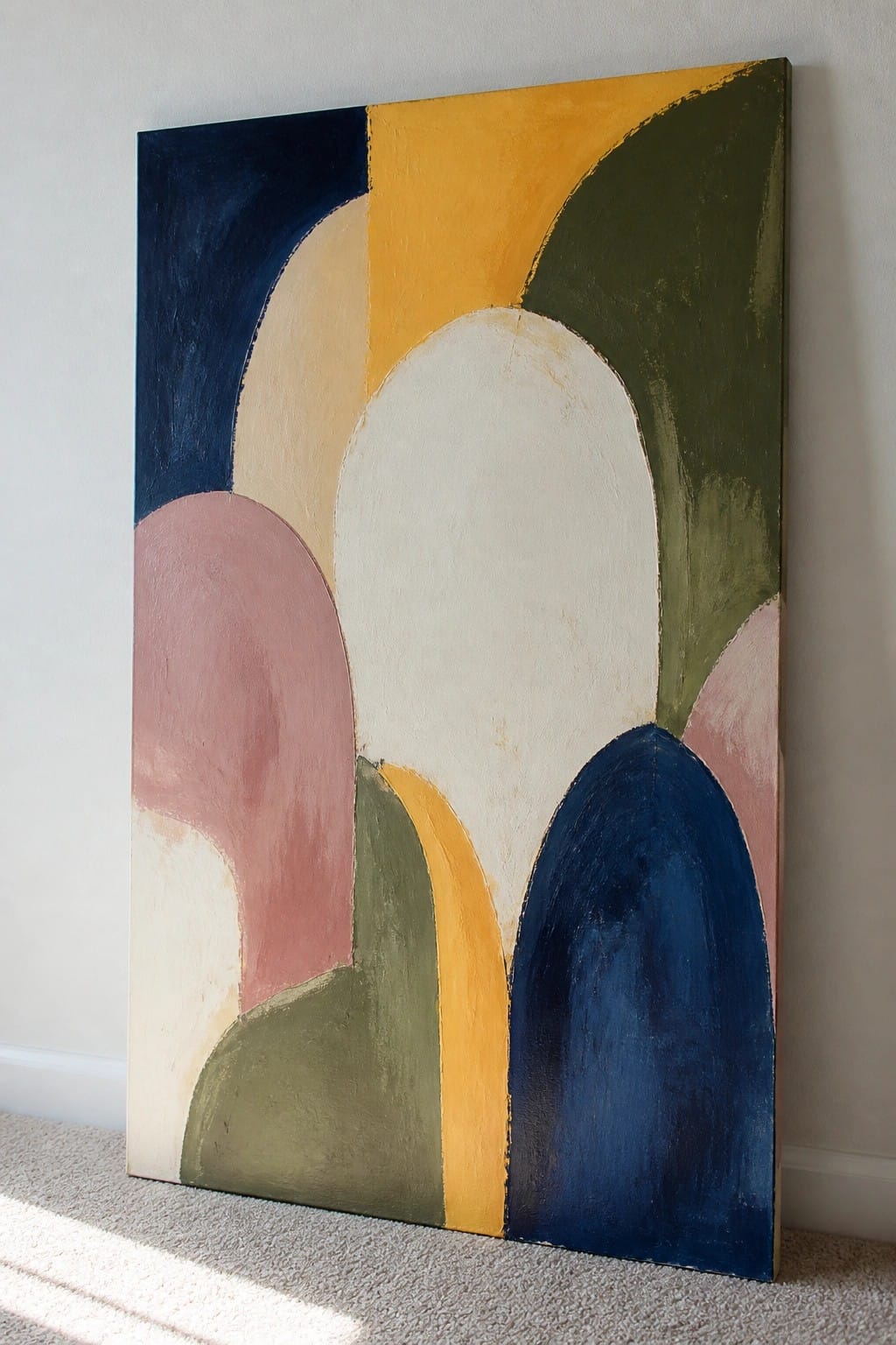 Abstract painting with overlapping curves in blue, yellow, green, pink and white against wall.