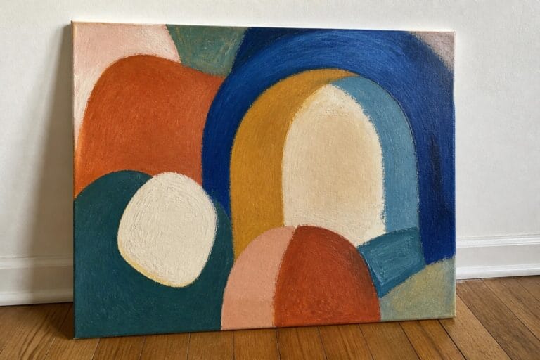22 Bold Abstract Oil Painting Ideas For Beginner Artists Abstract painting with bold colorful shapes leaning against wall on wooden floor.