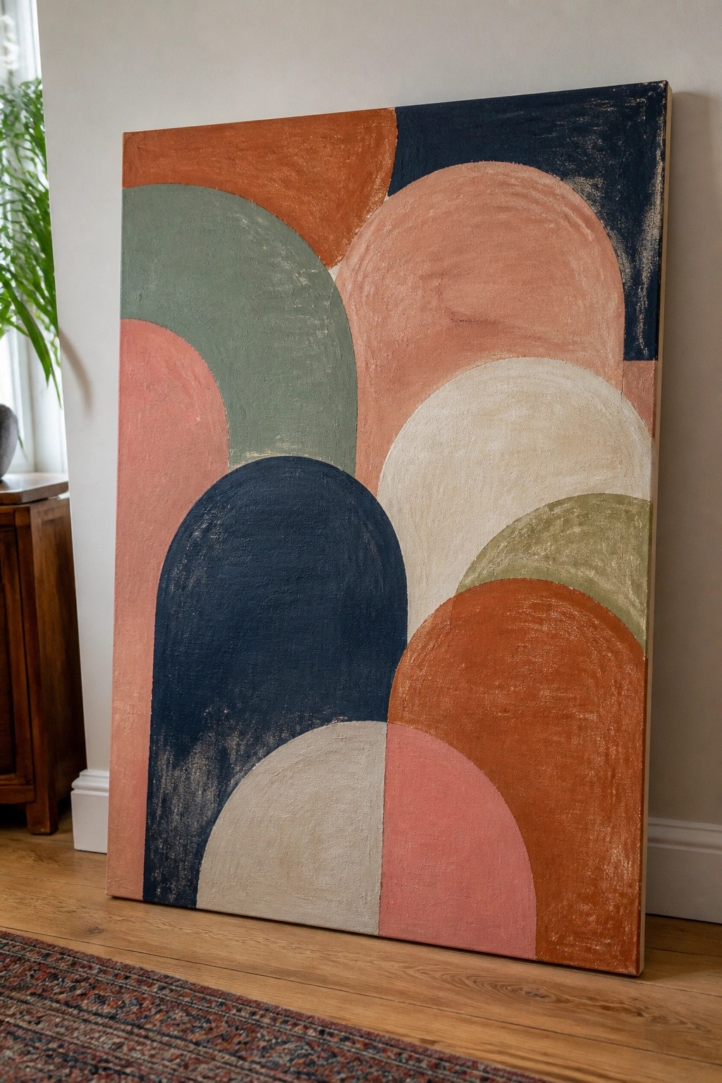 Abstract painting with overlapping semicircles in navy, terracotta, peach, and sage green
