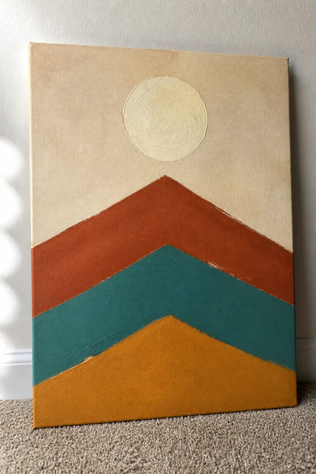 Abstract painting with beige background, white circle, and chevrons in orange, teal, yellow.