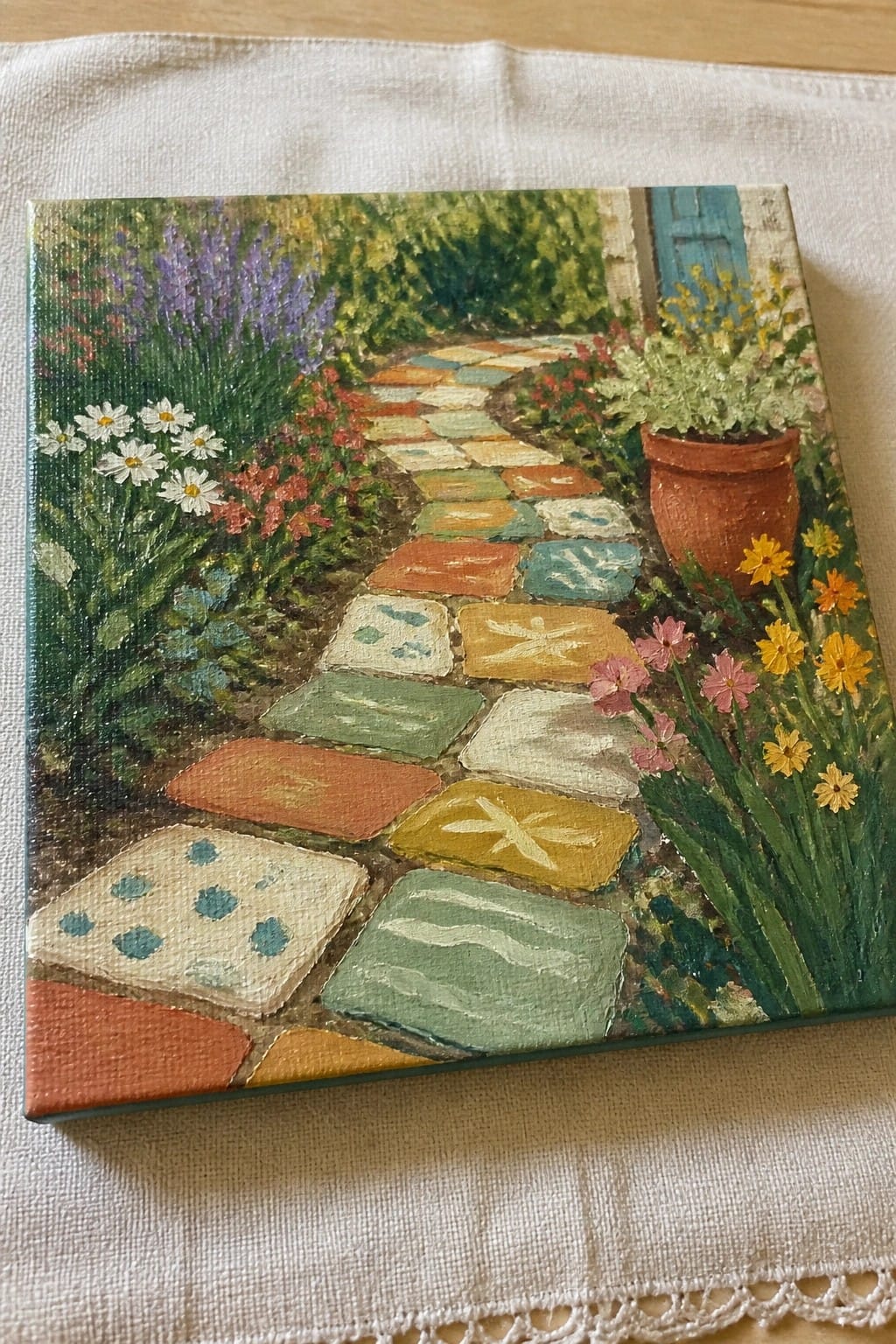 Colorful winding stone path through lush garden with daisies, lavender, and terracotta pot
