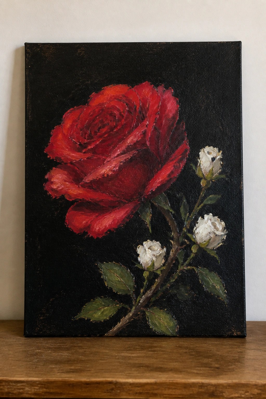 Vibrant red rose with white buds and green leaves on black background.