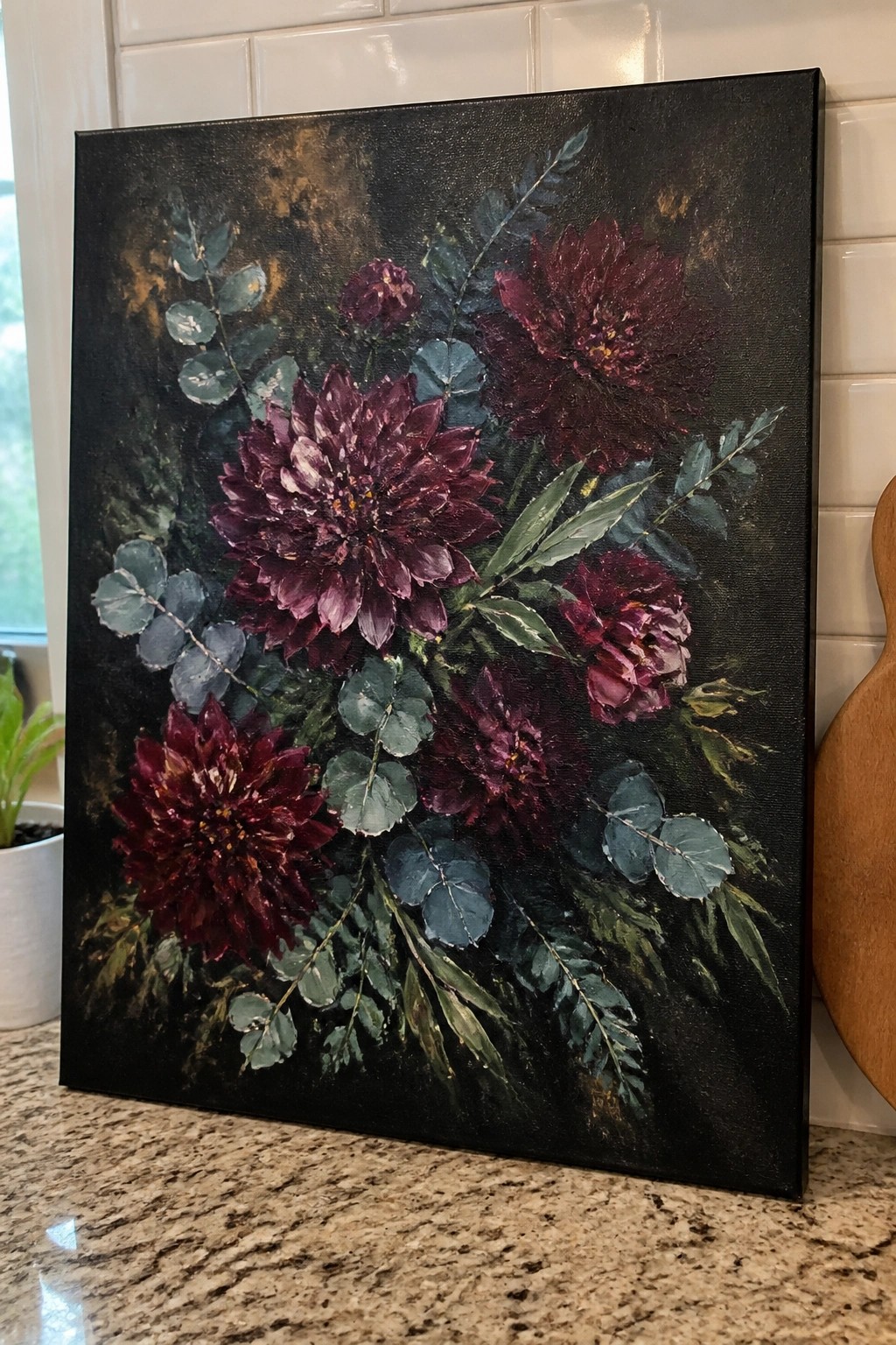 Painting of dark burgundy dahlias with blue-green leaves on black canvas