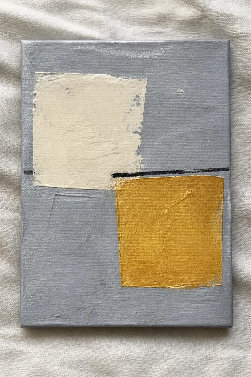 Abstract painting on gray canvas with beige shape, yellow square, black lines on white fabric