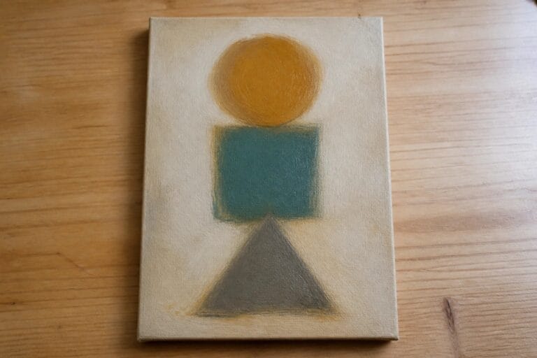 22 Easy Oil Painting Ideas for Beginners Practicing Simple Shapes and Soft Blending Abstract painting with yellow circle above teal square and gray triangle on pale canvas.