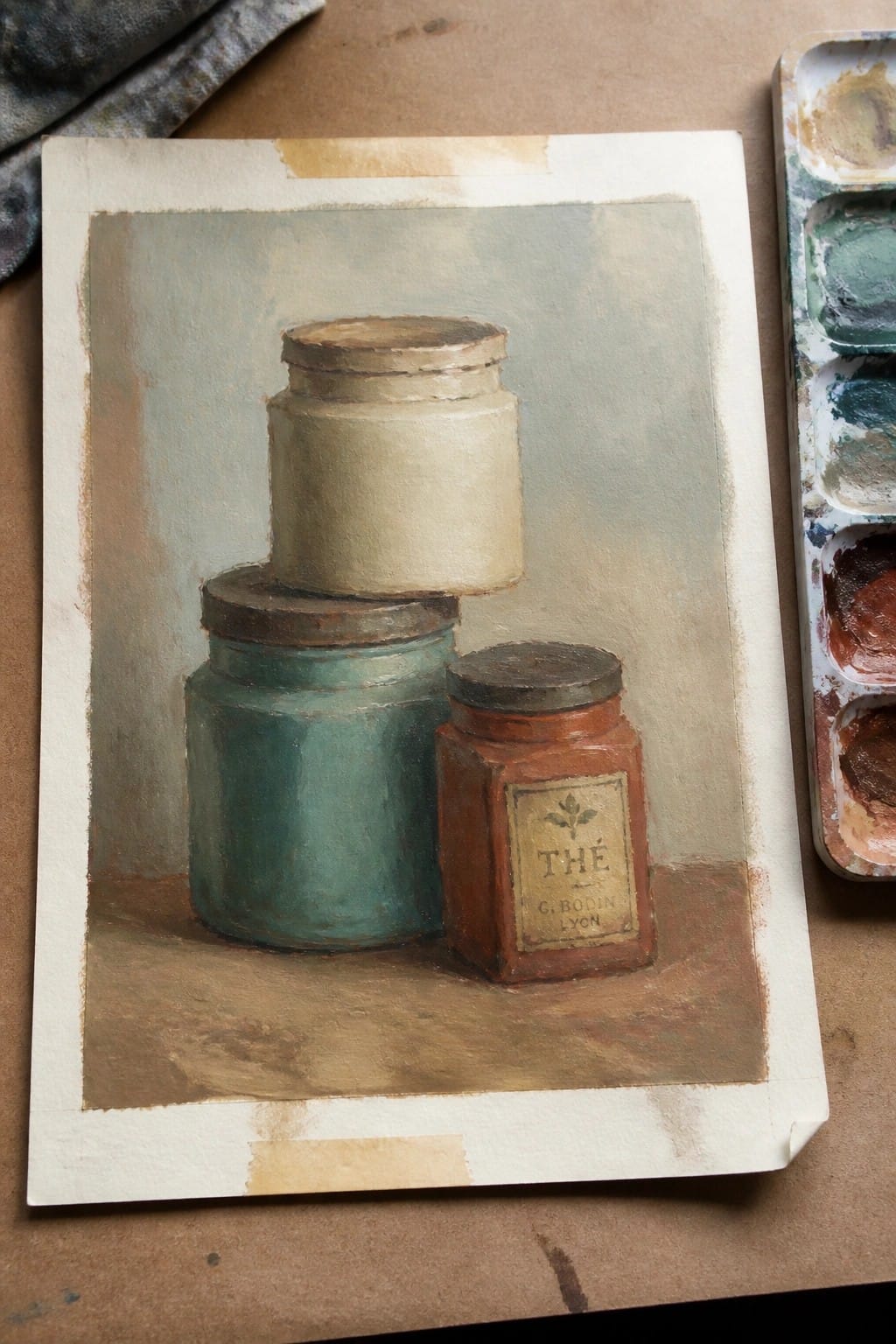 Still life painting of three jars beside open watercolor palette on brown surface