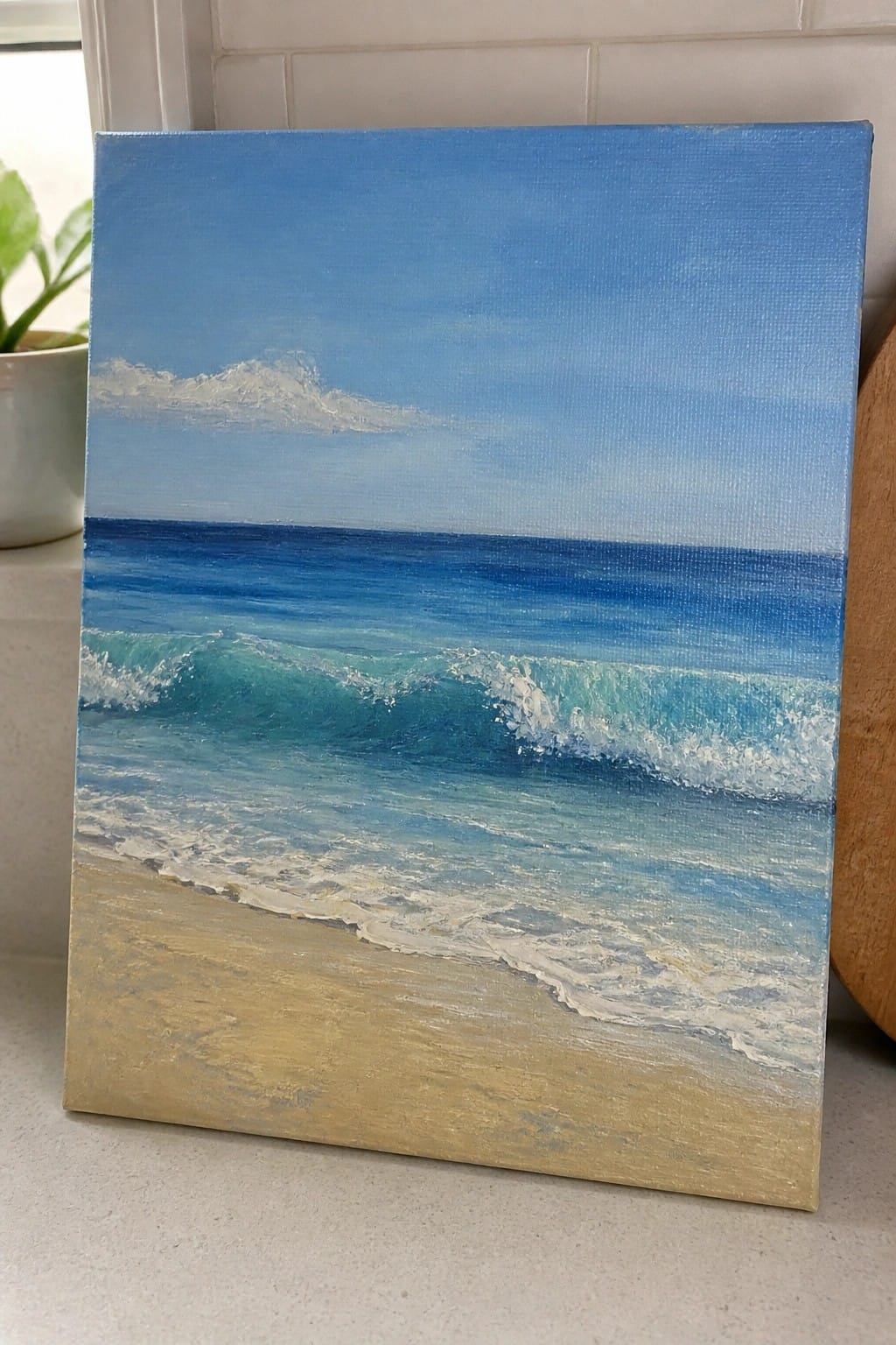 Canvas painting of turquoise waves rolling onto a sandy beach under blue sky.