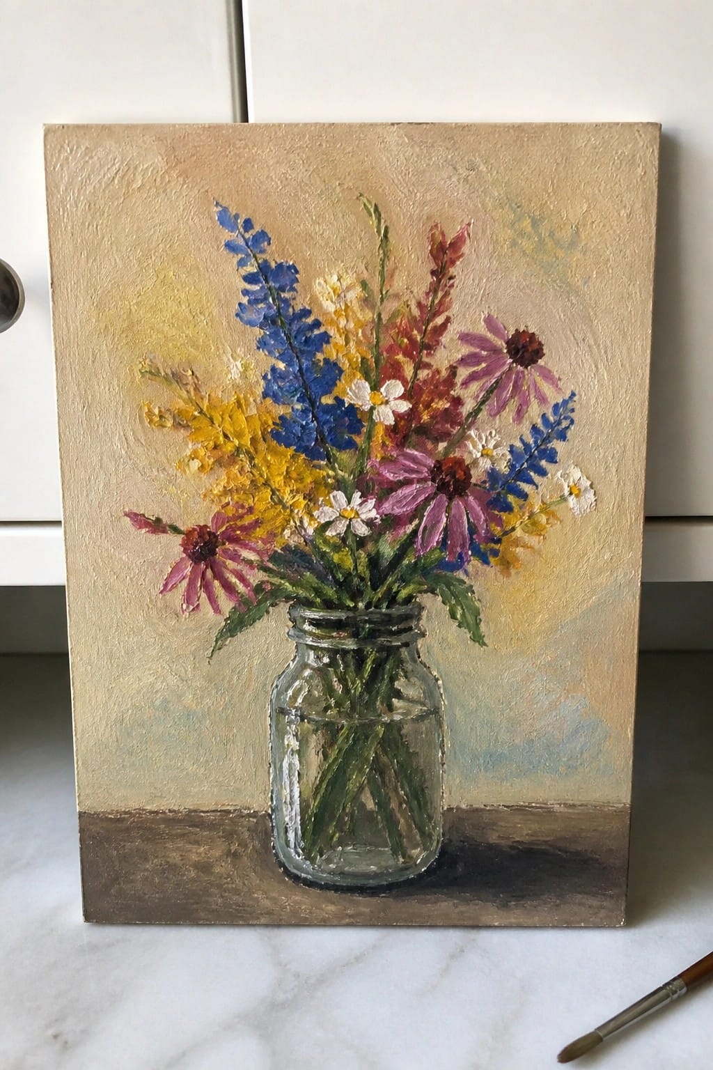 An oil painting of colorful wildflowers in a glass mason jar on a marble surface.