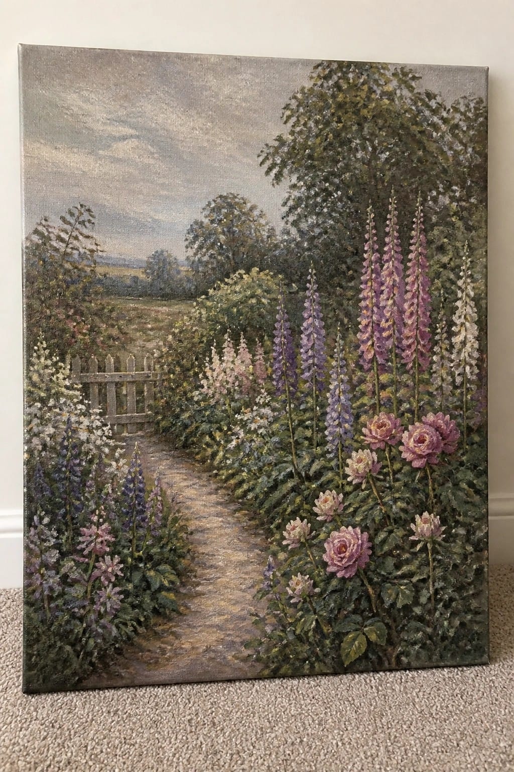 Garden path with pink roses and tall purple foxgloves leading to wooden gate