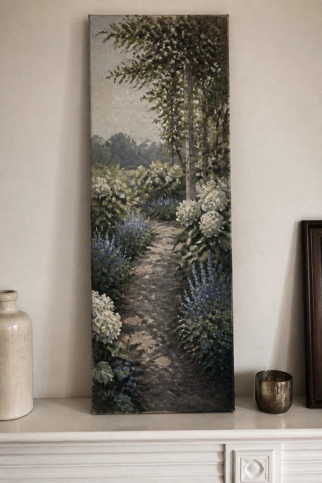 Vertical painting of garden path with white and blue flowers on white mantel