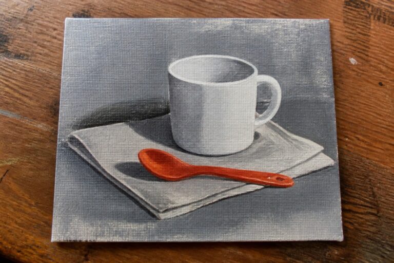 An oil painting of a white mug on a white cloth with an orange spoon placed in front of it on a gray background.