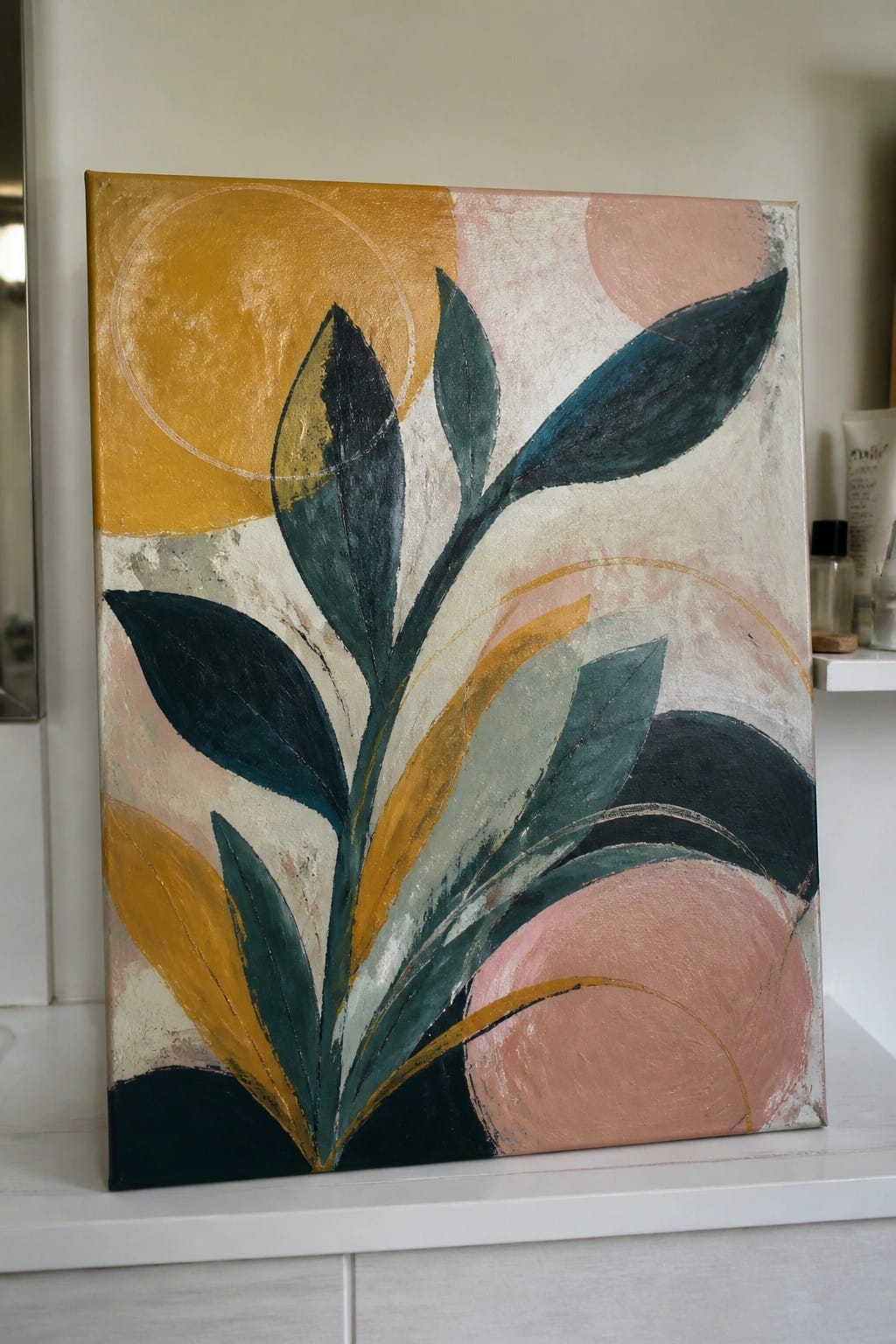 Abstract painting with green leaves, yellow accents, and pink circles on canvas.