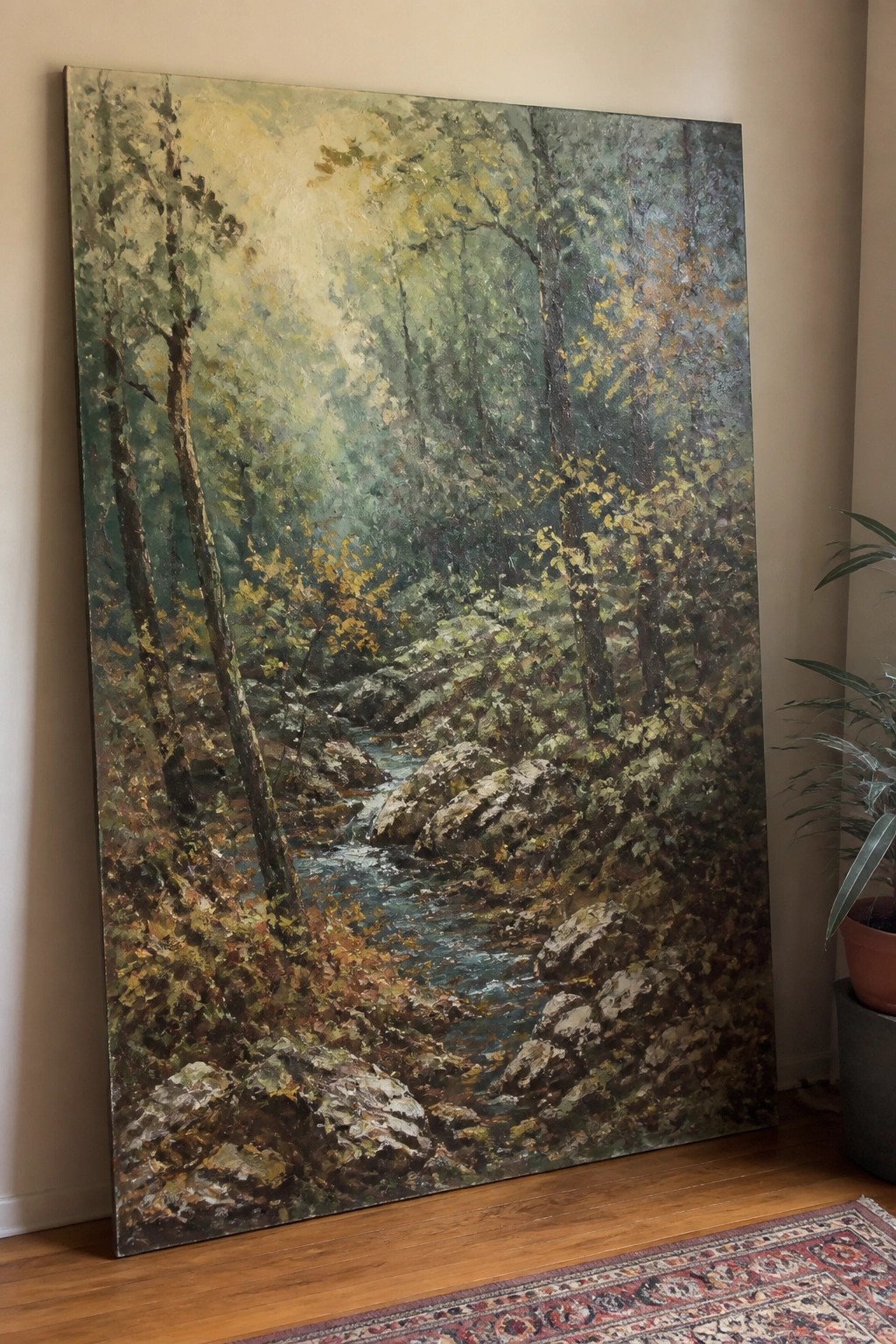 Large forest stream painting with autumn trees and rocks propped on wooden floor