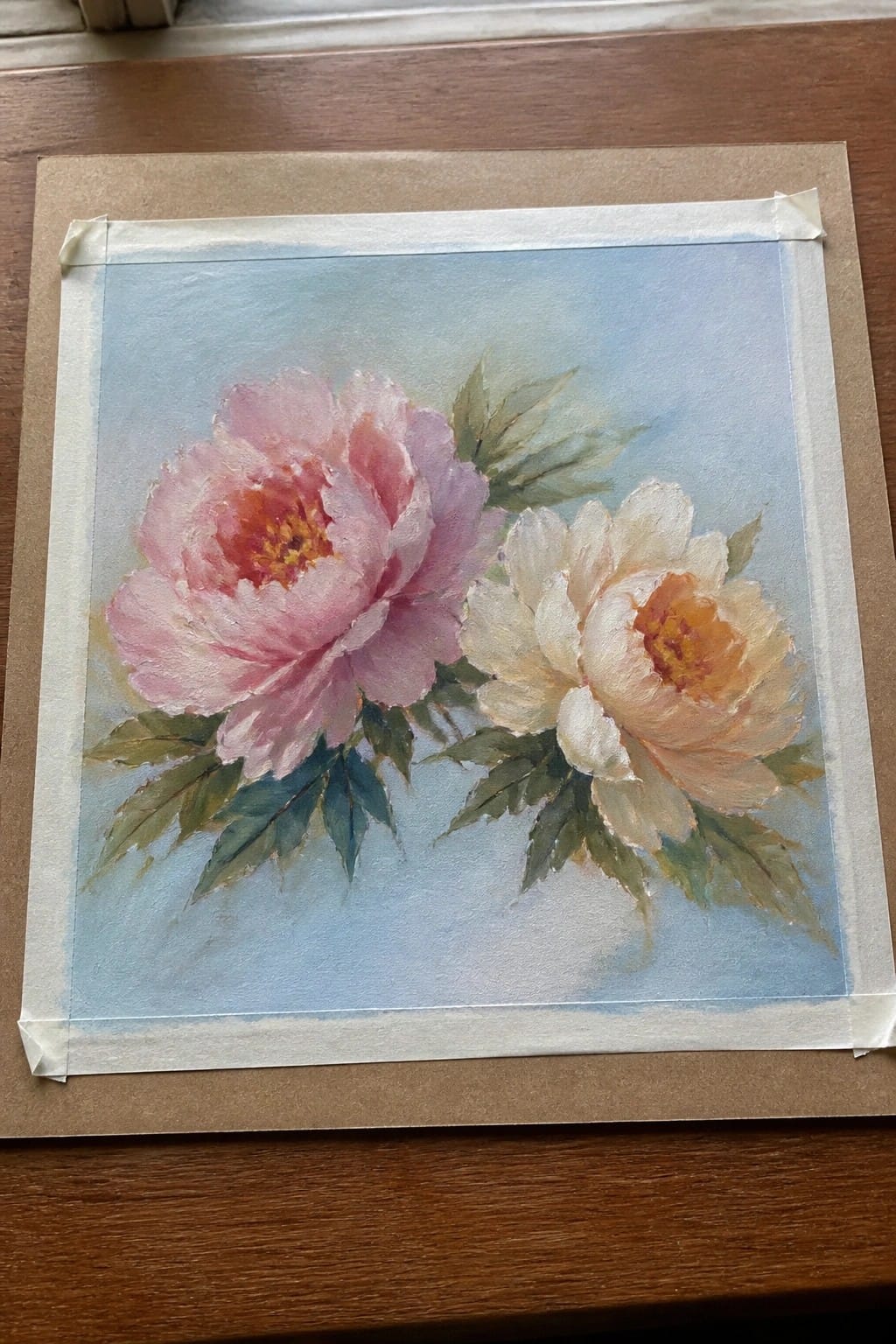 Pink and white peonies with green leaves on light blue painted background