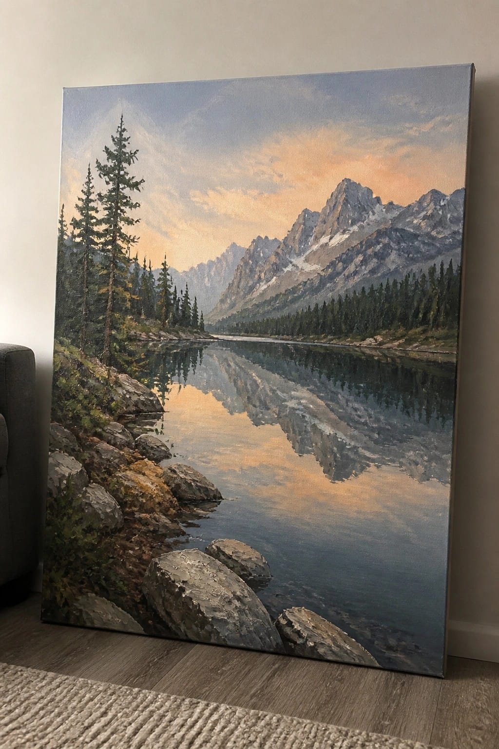 An oil painting depicts a calm lake reflecting snow-capped mountains under a colorful sunset sky, with evergreen trees and rocks along the shore.