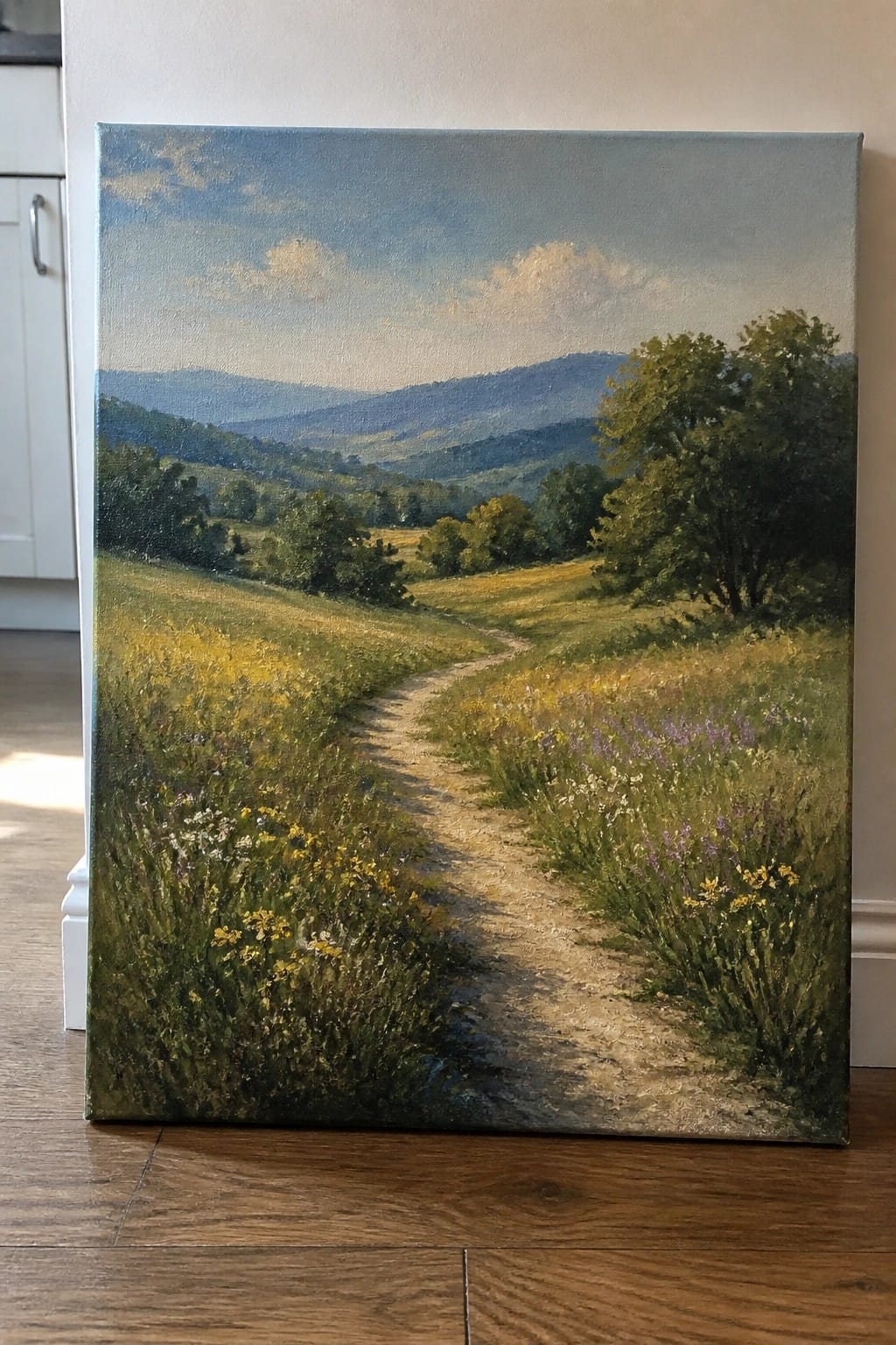 Winding dirt path through wildflower meadow toward misty blue mountains in oil painting.