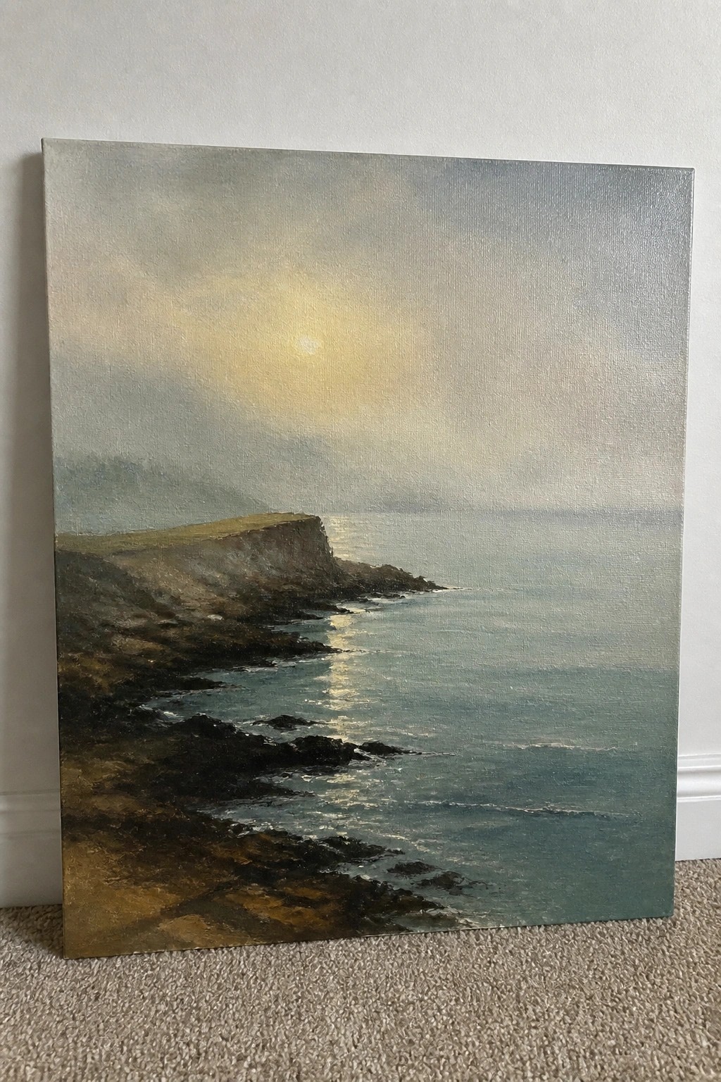 Hazy oil painting of rocky cliffs beside a sunlit, misty ocean.