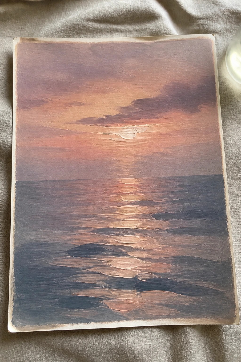 An oil painting of a sunset over the ocean with the sun low on the horizon and its reflection visible on the water, with darker waves in the foreground.