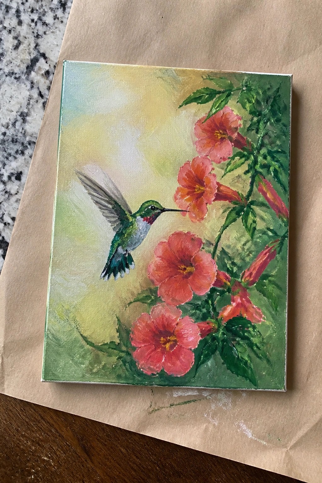 Hummingbird with green and white feathers hovers near red trumpet flowers in painting