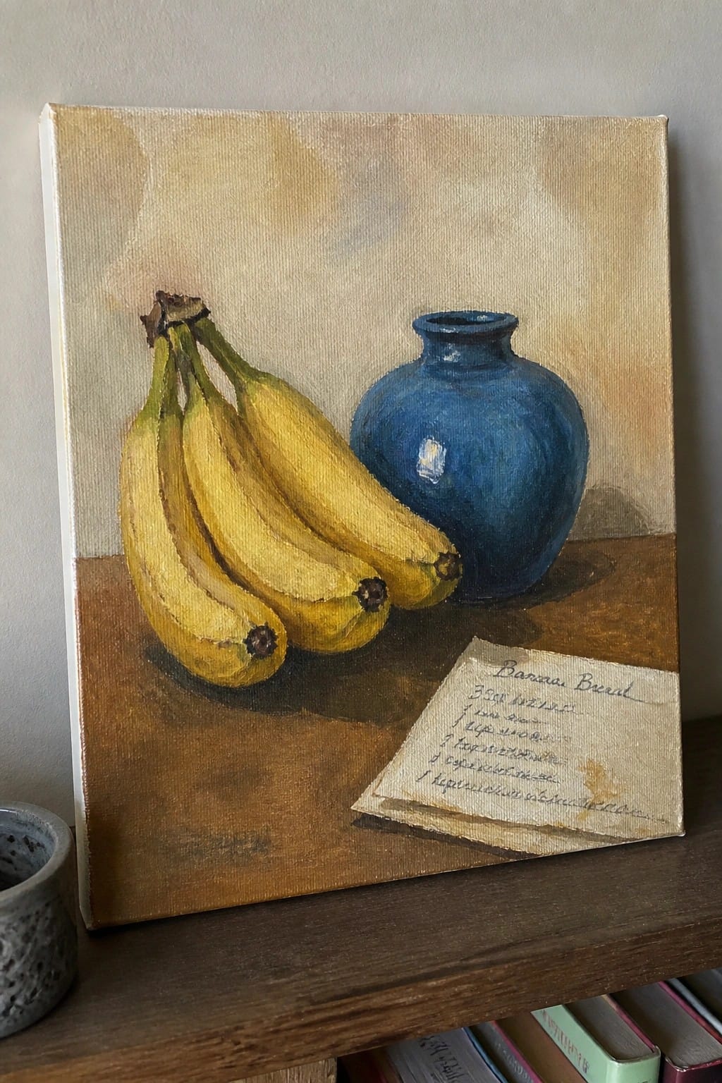 Still life painting of yellow bananas, blue vase, and banana bread recipe note.