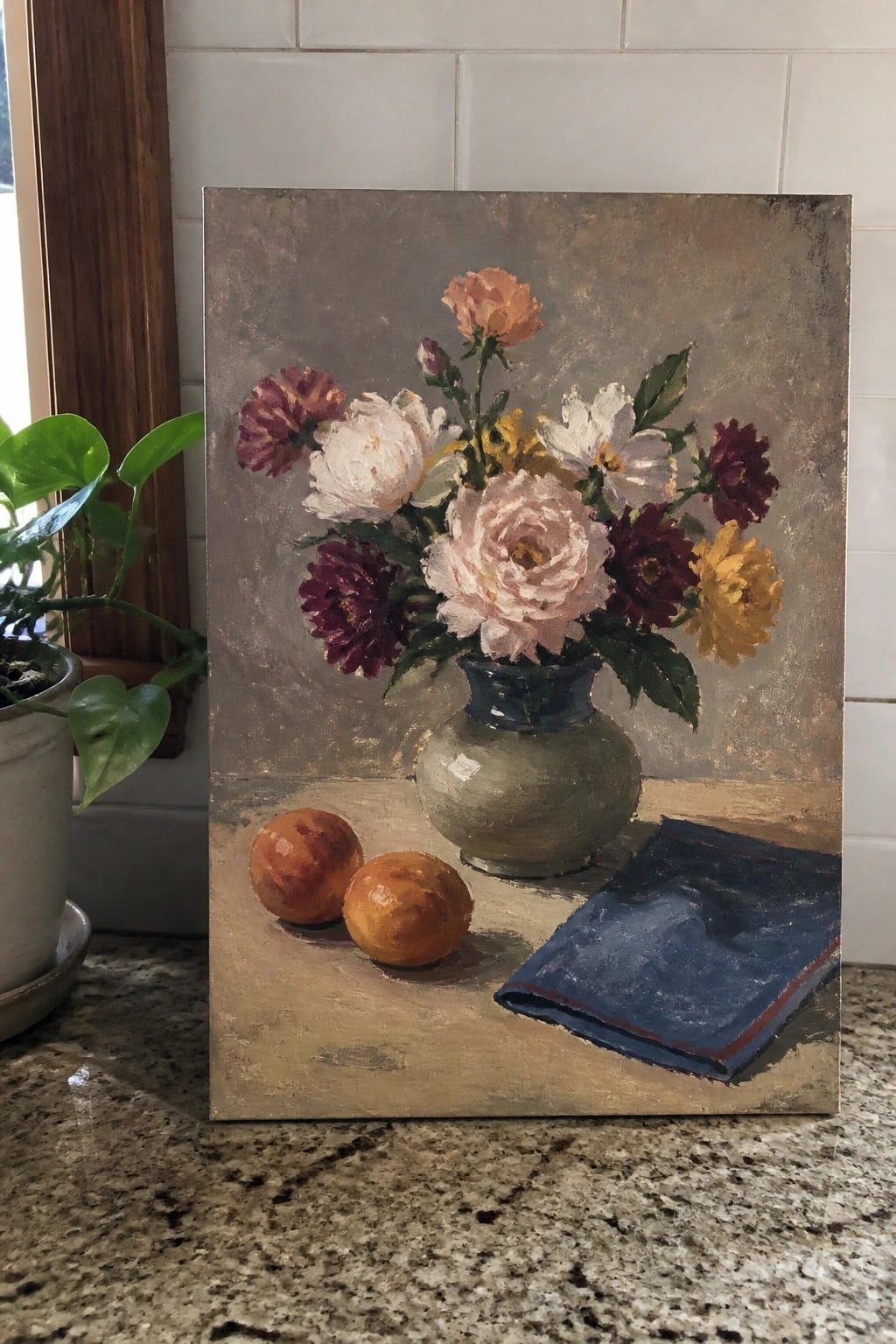 Still life painting of flowers in vase with oranges and blue cloth on table
