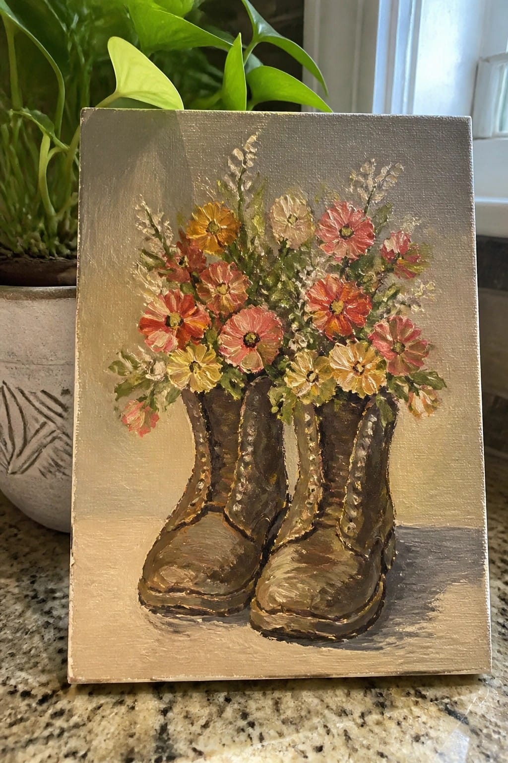 Oil painting of brown boots filled with vibrant red, orange, and yellow flowers on beige canvas