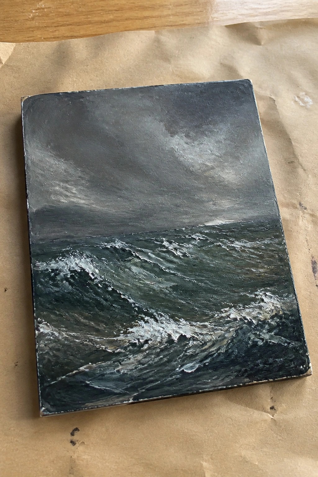 Textured oil painting of dark turbulent ocean waves under stormy gray skies on canvas.