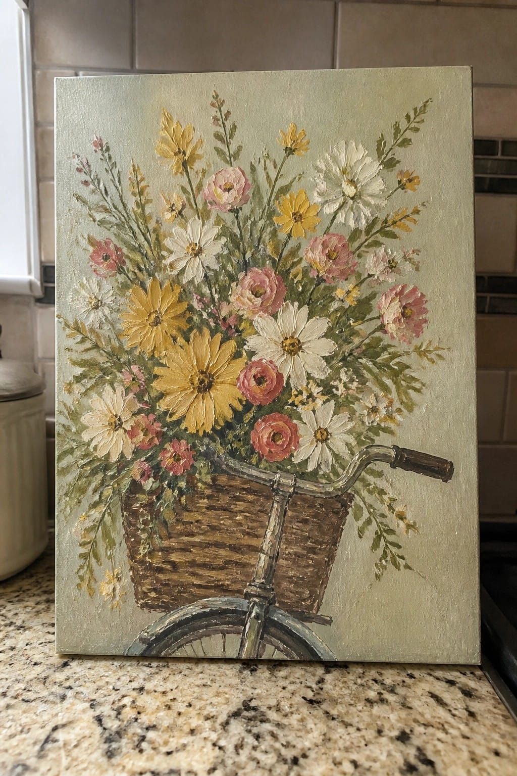 Oil painting of bicycle with wicker basket overflowing with yellow, pink, and white flowers