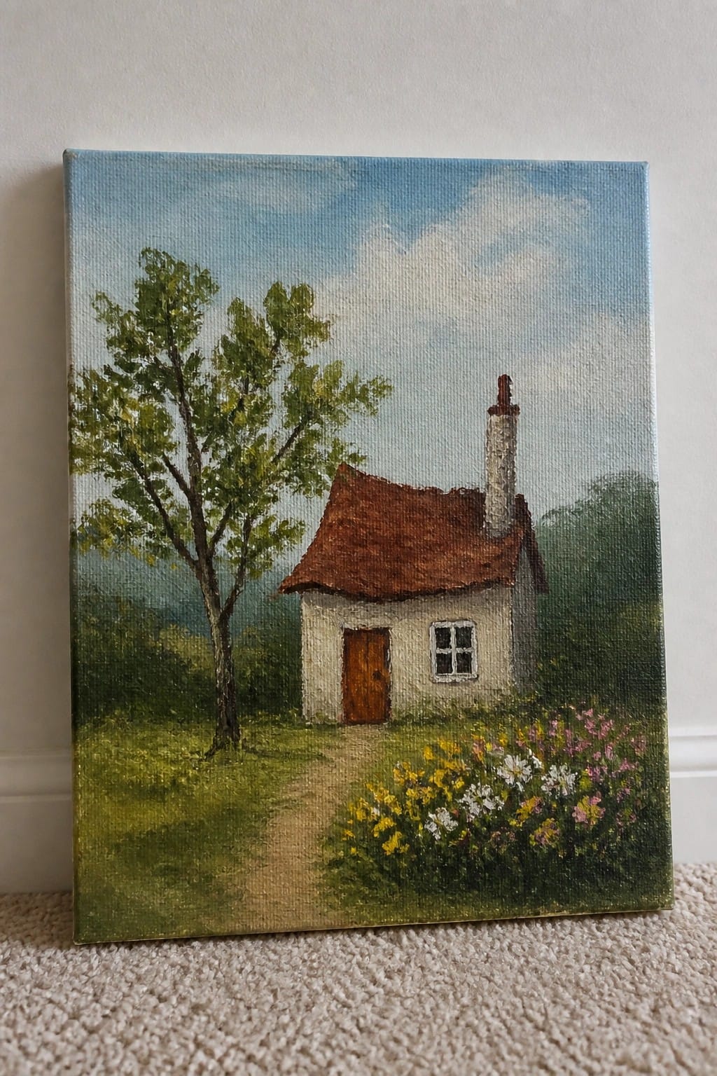 Oil painting of white cottage with brown roof, chimney, tree, path, and wildflowers.
