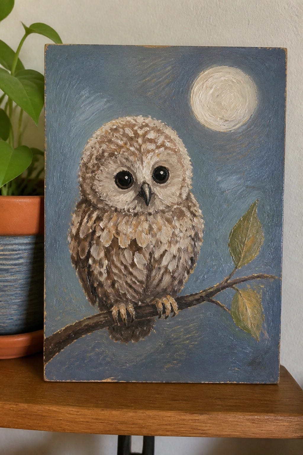 Brown owl with large eyes perches on branch under glowing full moon in blue sky.