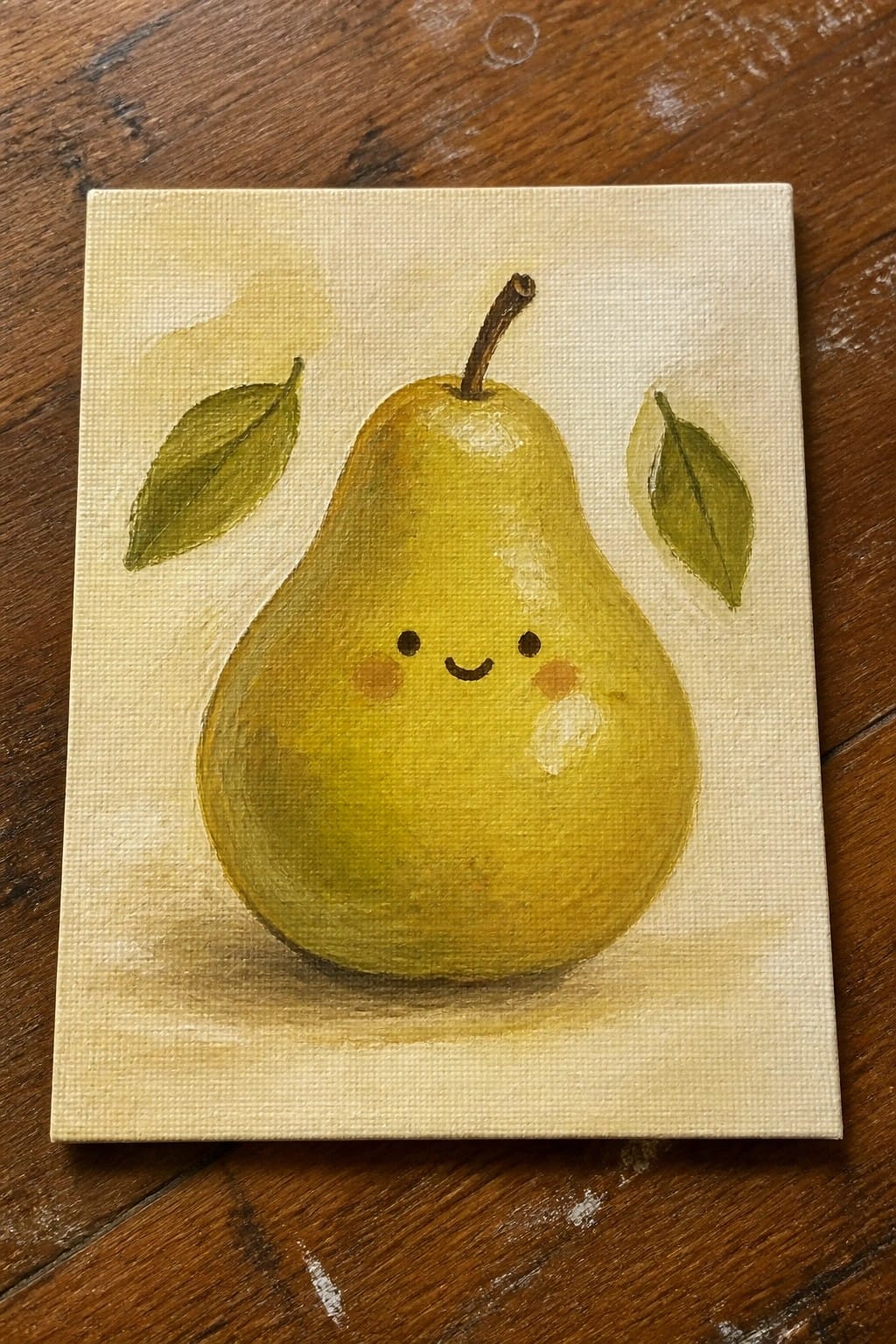 Yellow pear with smiling face and pink cheeks on canvas beside green leaves.