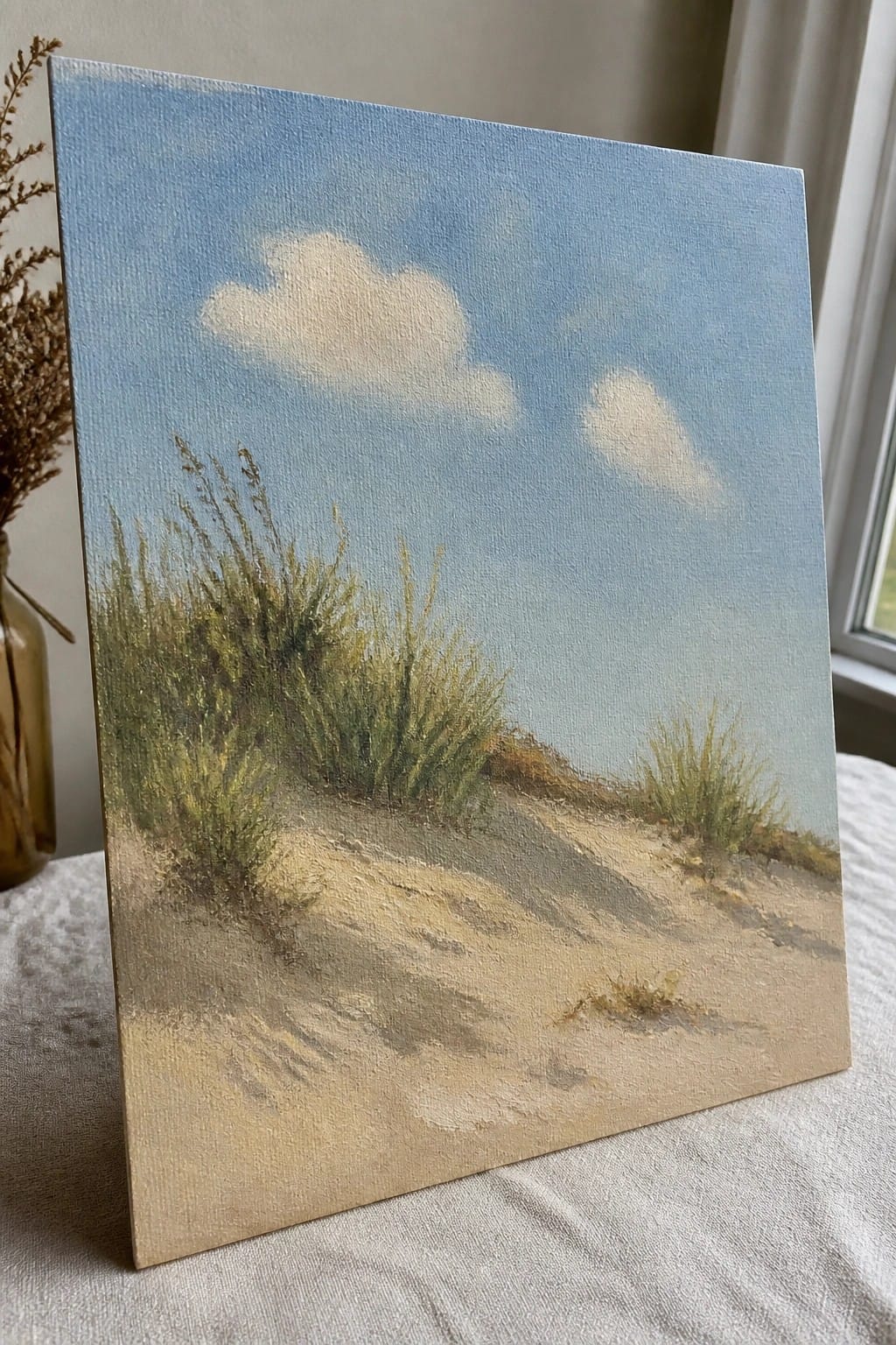 Sandy dune with green grasses under blue sky with white clouds on canvas