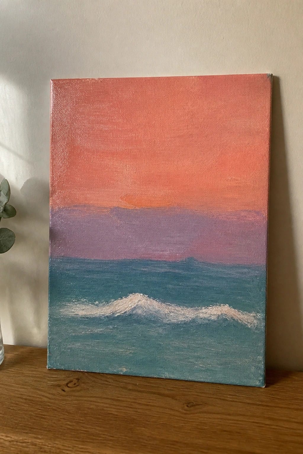 Canvas painting of pink-orange sunset sky over purple clouds and teal sea with white wave