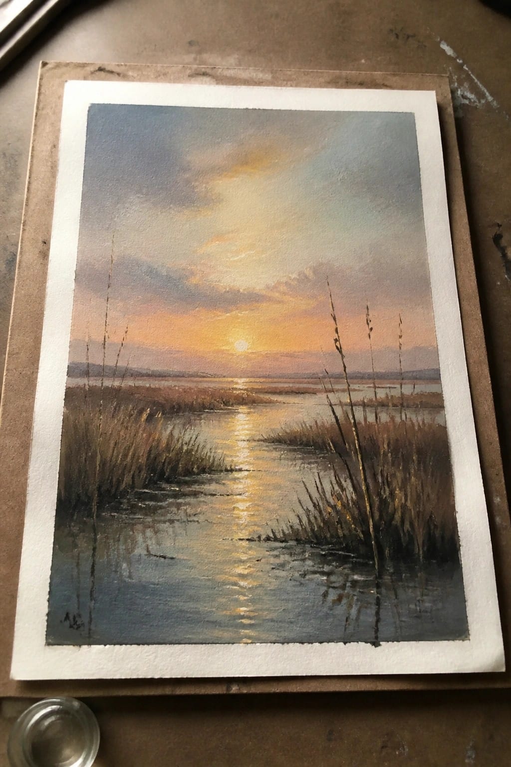 Watercolor sunset over marsh reeds with golden sun reflection on calm water
