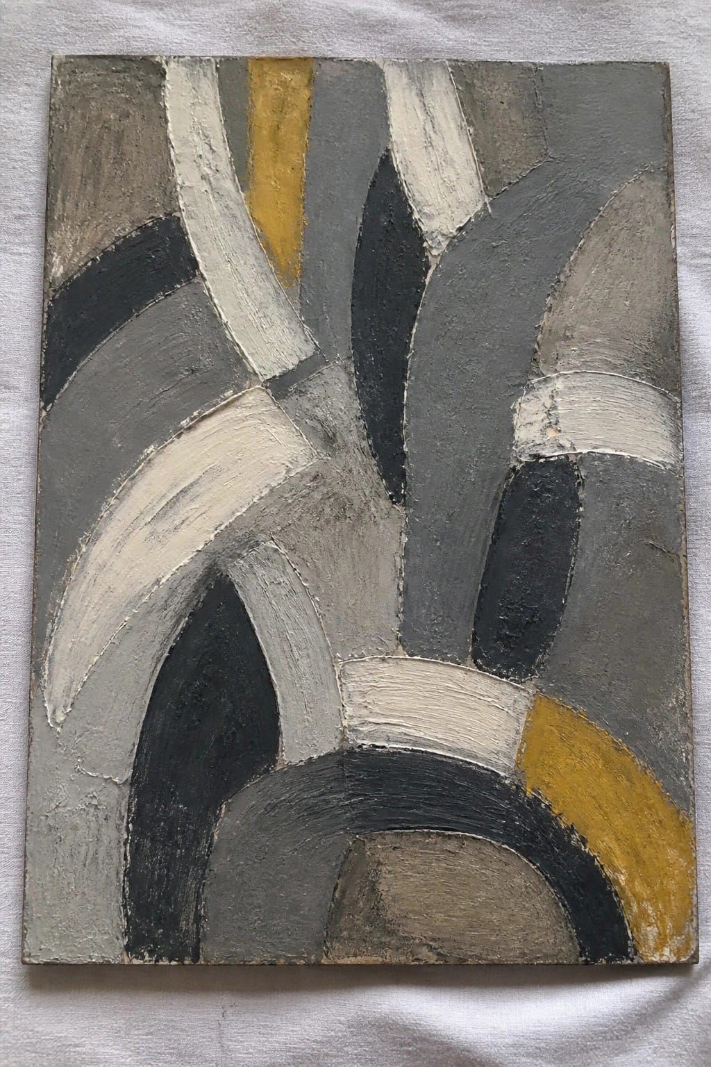 An abstract oil painting featuring thick impasto brushstrokes in gray, black, white, and yellow forming overlapping curved and angular shapes.