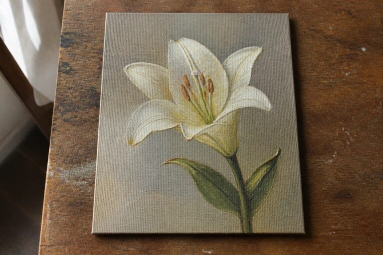 23 Realistic Flower Oil Painting Ideas That Showcase Fine Botanical Detail White lily with green leaves painted on canvas atop wooden table