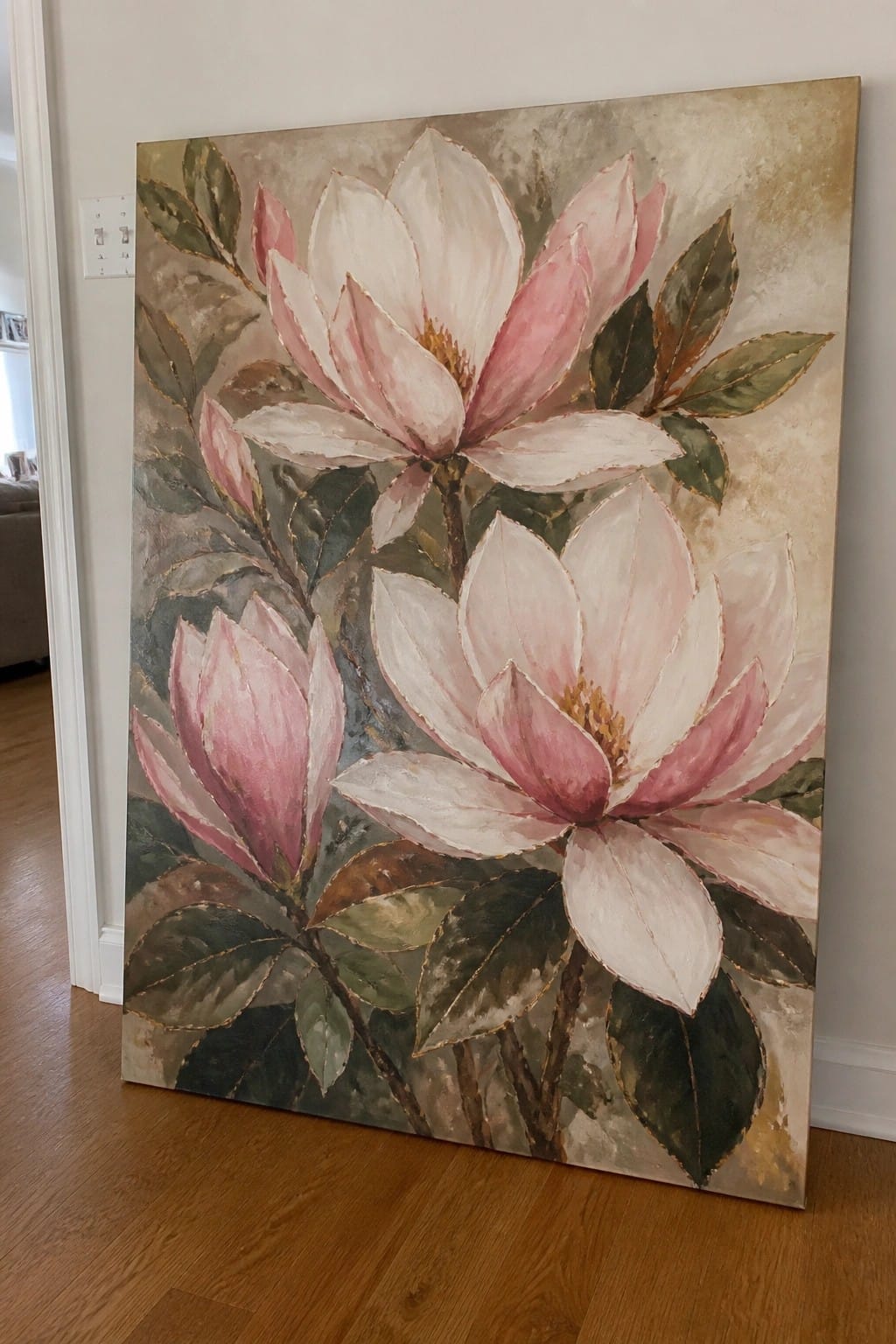 Large painting of pink-and-white magnolias with green leaves and gold accents on canvas.