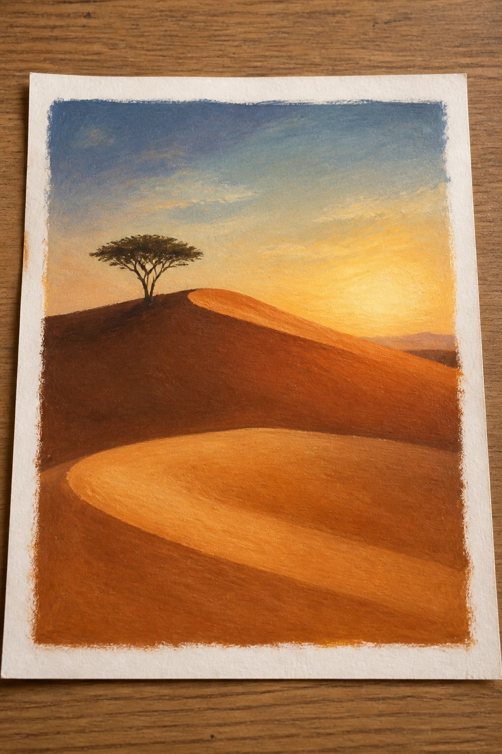 Rolling orange hills with lone tree under blue-yellow sunset sky in painting.