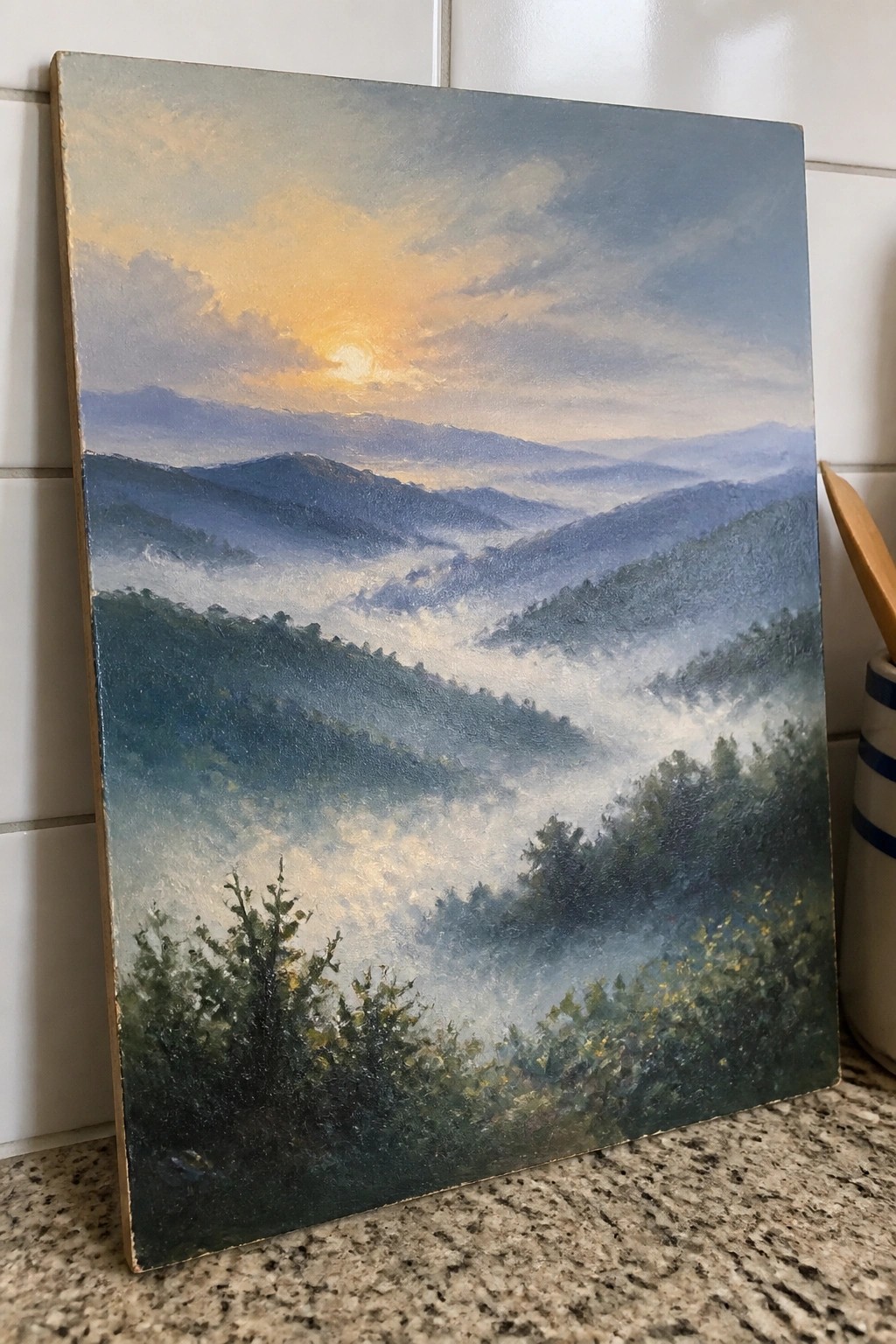 Mountain landscape painting with misty valleys and golden sunrise over hills
