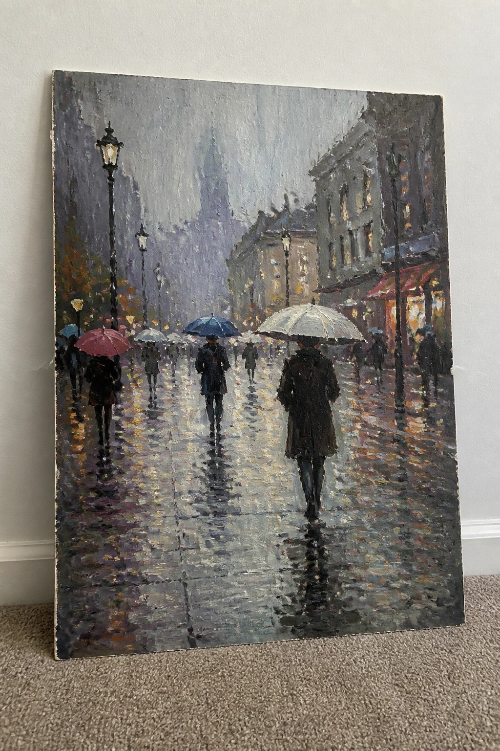 Impressionist painting of people with umbrellas strolling on a rainy, lamp-lit city street.