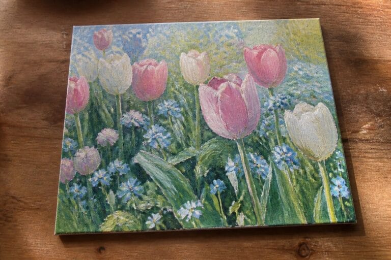 23 Vibrant Flower Garden Oil Painting Ideas That Capture Seasonal Blooms Vibrant painting of pink and white tulips amid clusters of blue forget-me-nots on canvas