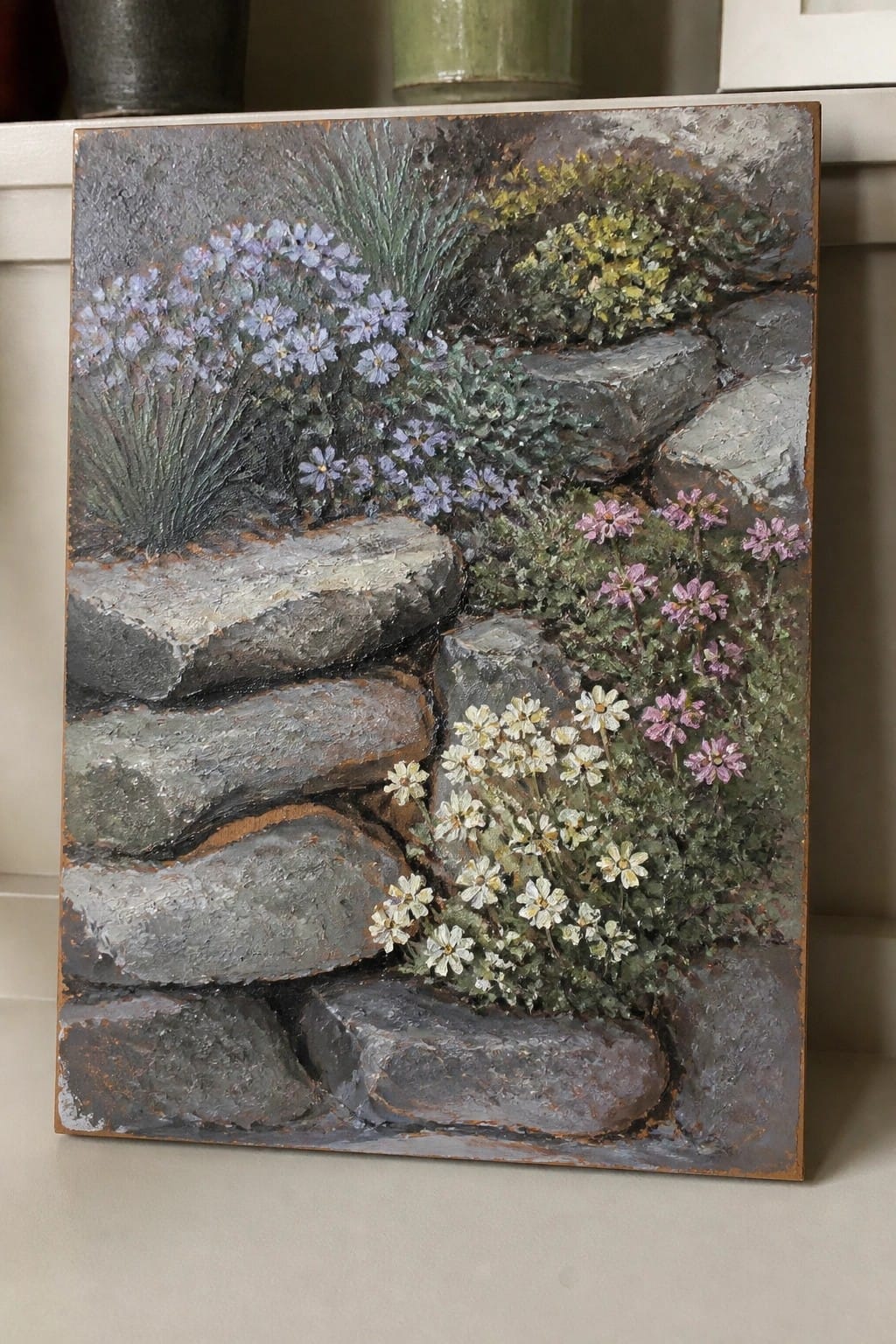 Textured painting of a stone wall with purple, white, and pink wildflowers.