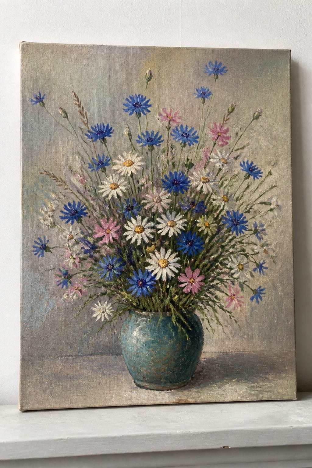 Painting of blue cornflowers, daisies, and pink blooms in a teal vase.