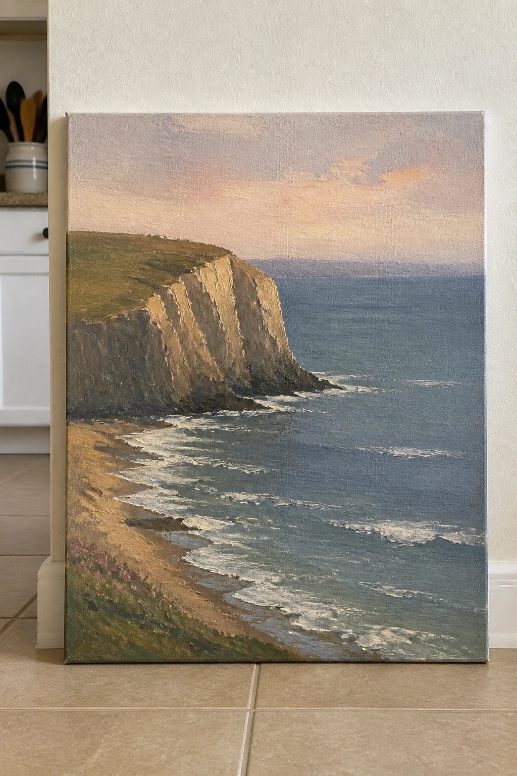 Oil painting of white cliffs, sandy beach, and blue ocean under pastel sunset sky