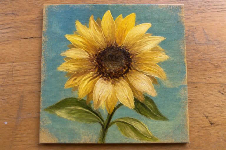 24 Beginner-Friendly Canvas Oil Painting Projects That Build Brushstroke Confidence Yellow sunflower painting with green leaves on textured teal canvas over wood