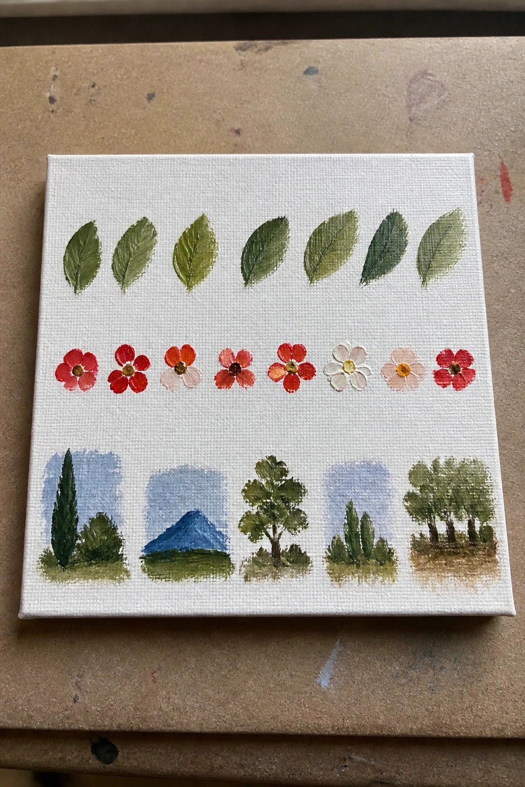 White canvas with rows of green leaves, colorful flowers, and miniature landscapes