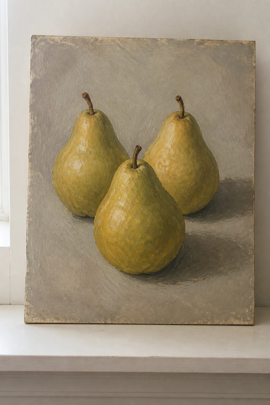 Three yellow-green pears on a textured gray canvas with soft shadows