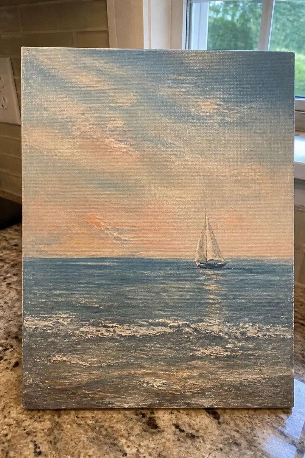 Lone sailboat on choppy seas under cloudy sky with orange sunset hues
