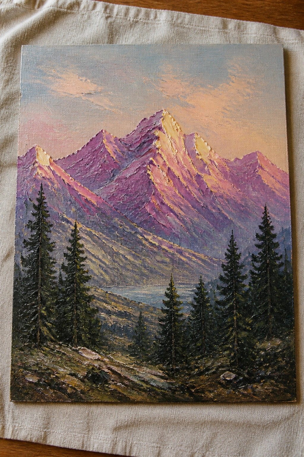 Impasto oil painting of purple mountains at sunset with pine trees in foreground